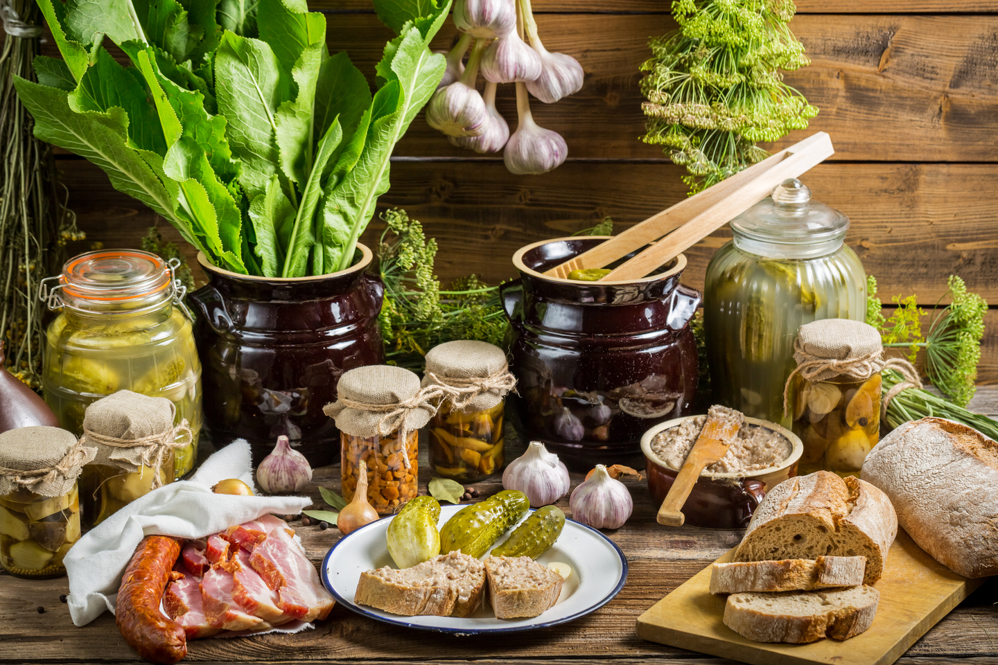 Selección de alimentos artesanos como pan, quesos y embutidos sobre una mesa de madera, representando la esencia del sabor artesano